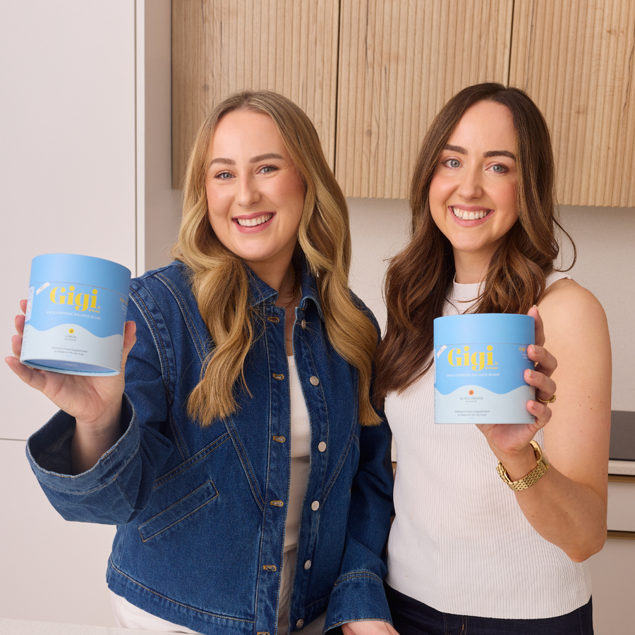 Gigi founders Jennie and Lisa holding tubs of PMS and Hormone Balance Blend
