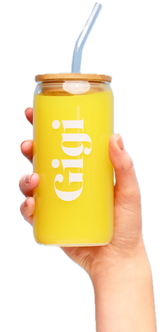 Hand holding a Gigi glass tumbler of yellow Lemon PMS & Hormone Balance Blend with a glass straw